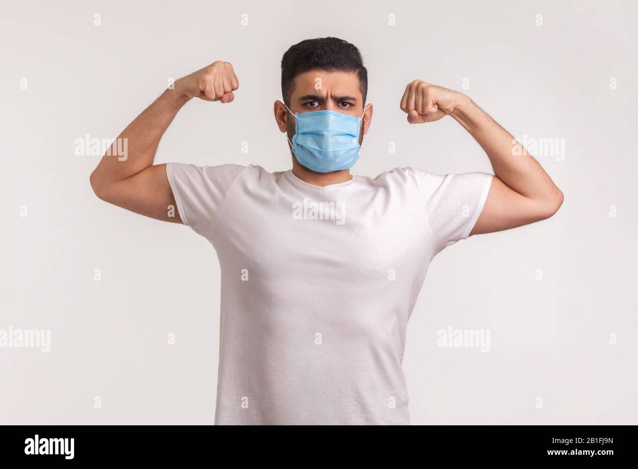 Uomo in maschera igienica che mostra forza e immunità per recuperare da malattie contagiose, malattie respiratorie aeree come l'influenza, coronavirus 2019-nCoV Foto Stock
