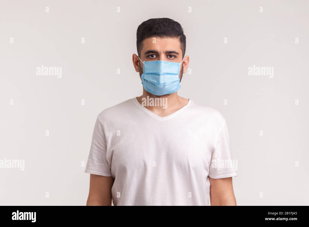 Protezione contro le malattie contagiose, il coronavirus. Uomo che indossa una maschera igienica per prevenire infezioni, malattie respiratorie aeree come l'influenza, 2019-NCO Foto Stock