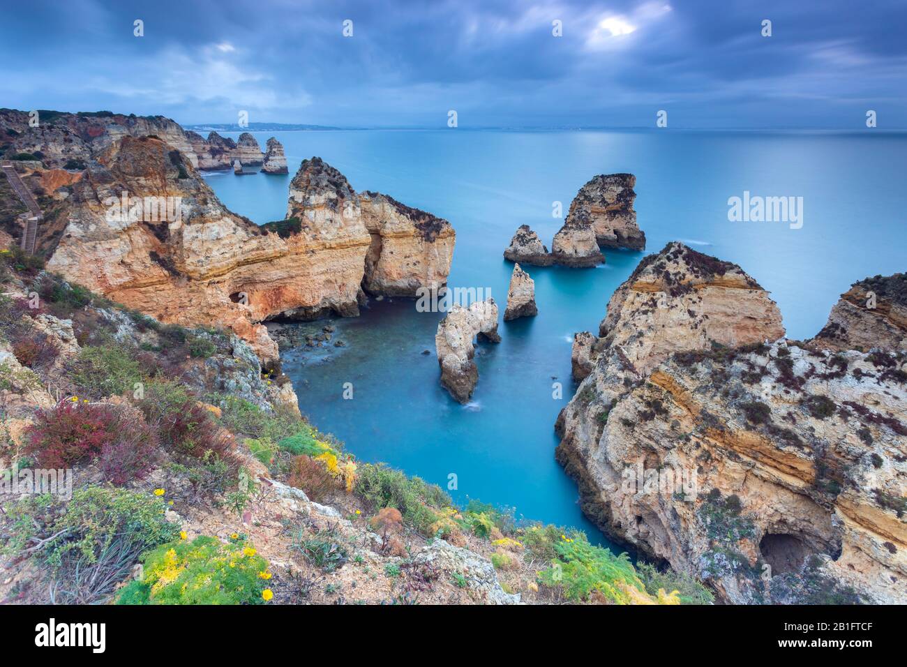 Alba nuvoloso alle scogliere gialle e rosse di Ponta da Piedade. Lagos, Algarve, Portogallo, Europa. Foto Stock