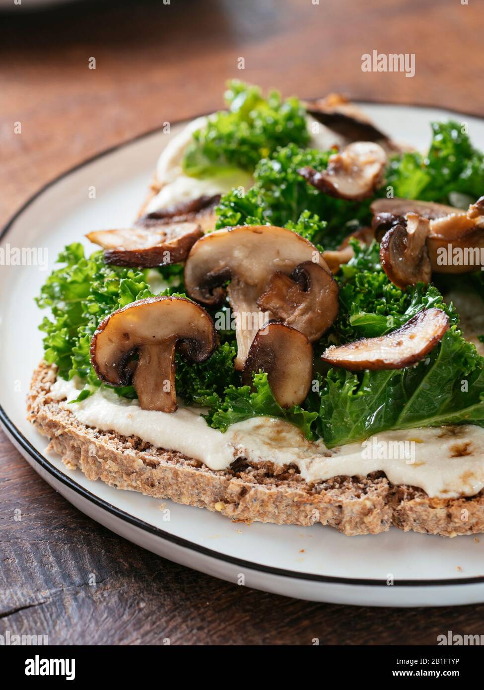 Funghi e Kale con ricotta vegana Su Toast Foto Stock