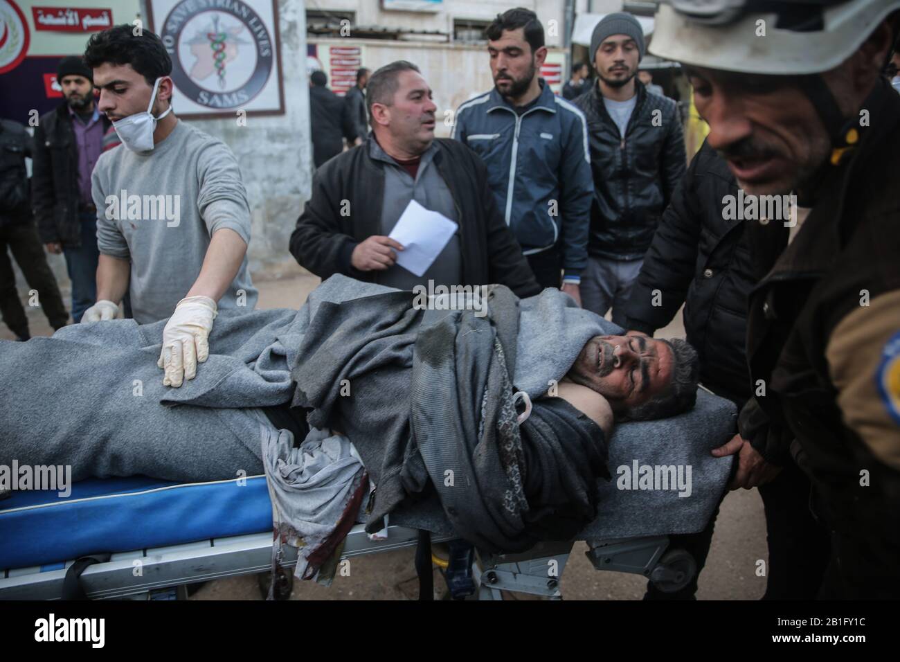 Maarrat Misrin, Siria. 25th Feb, 2020. Le persone portano via il corpo di una vittima di un attacco aereo, presumibilmente effettuato da forze siriane belliche, che si sono rivolte a una scuola abitata da sfollati nella provincia di Idlib, tenuta dai ribelli. Credito: Anas Alkforhoutli/Dpa/Alamy Live News Foto Stock