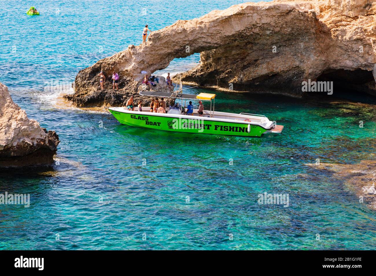 Barca con fondo in vetro con turisti al Love Bridge e grotte marine ad Ayia Napa, Cipro. Foto Stock