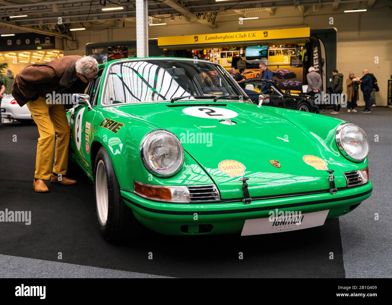 22 Feb 2020 - Londra, Regno Unito. Vecchio uomo curiosamente controllo su un classico modello Porsche 911 al Classic Car Show di Londra. Foto Stock