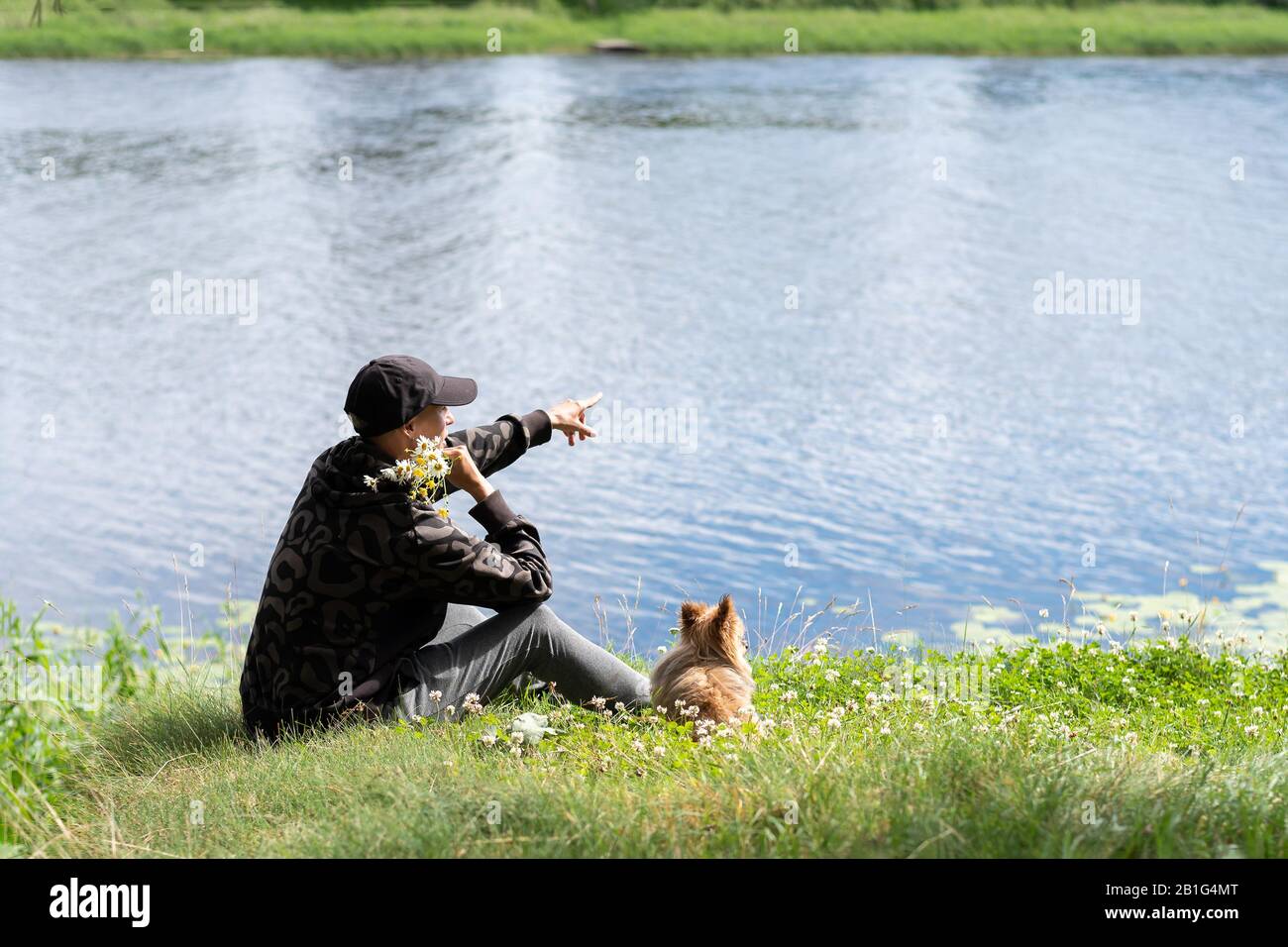 Una donna con un cane sul lago in estate. Foto Stock