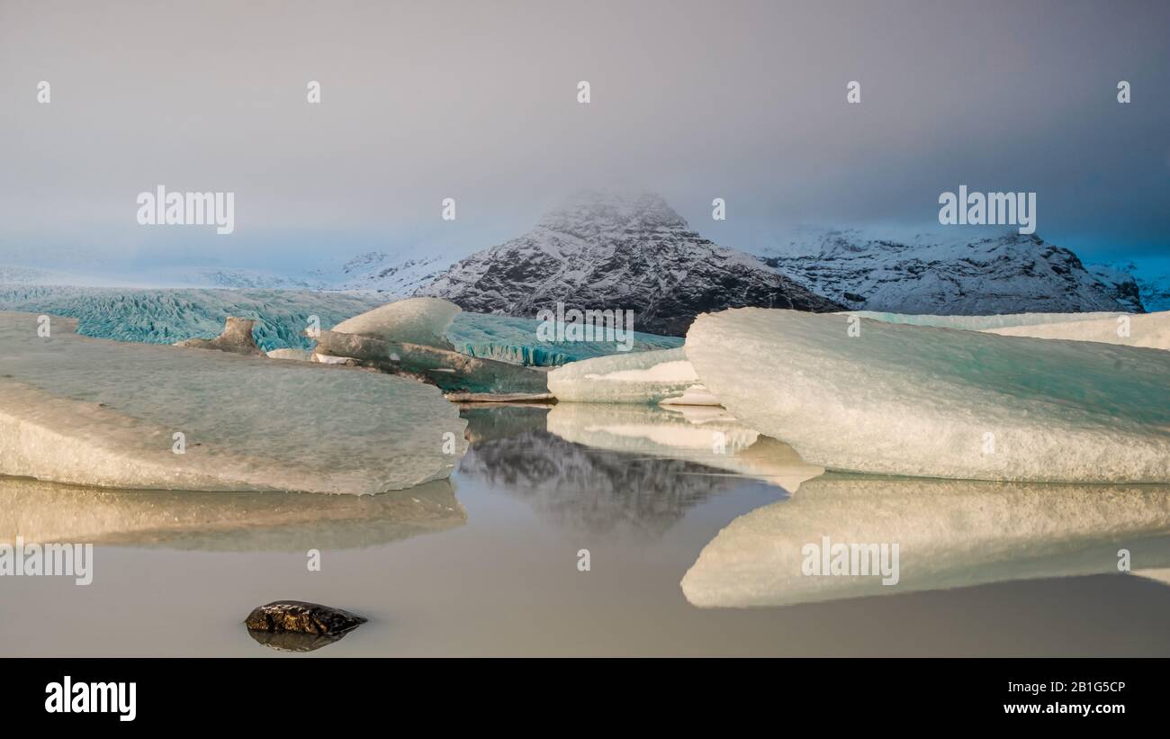 Iceberg e montagne riflesse in un lago. Islanda, inverno. Foto Stock