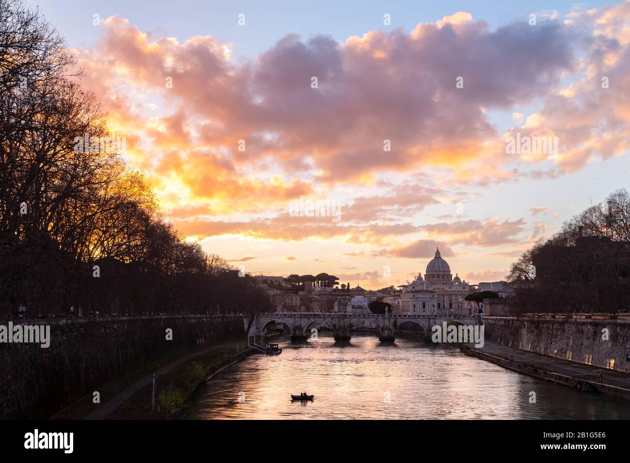 Tramonto a Roma di fronte alla Basilica di San Pietro, al ponte di Sant'Angelo e al fiume Tevere dal ponte Umberto I. Foto Stock