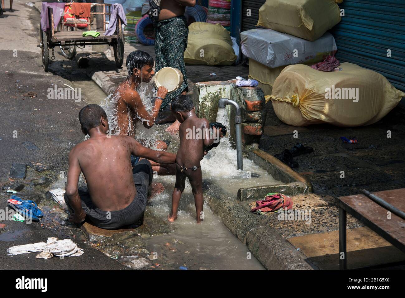 L'immagine di uomini che prendono il bagno nelle strade del porto di Kolkata, Bengala Occidentale. India, Asia Foto Stock