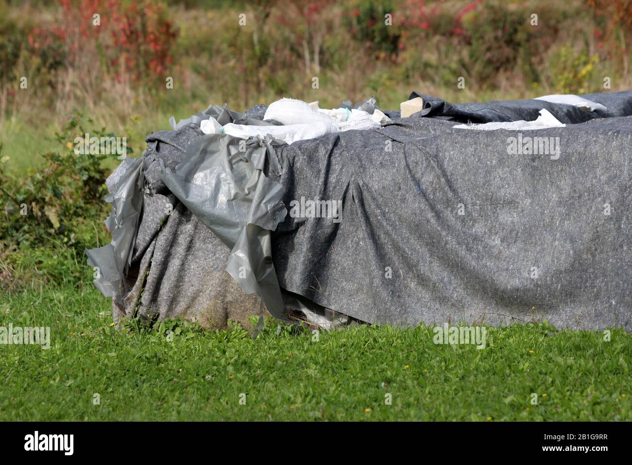 Una protezione antiesondazione temporanea parete realizzata con scatola di barriere e sacchi di sabbia coperte di fitti panno in geotessile e nylon utilizzato per proteggere case famiglia Foto Stock