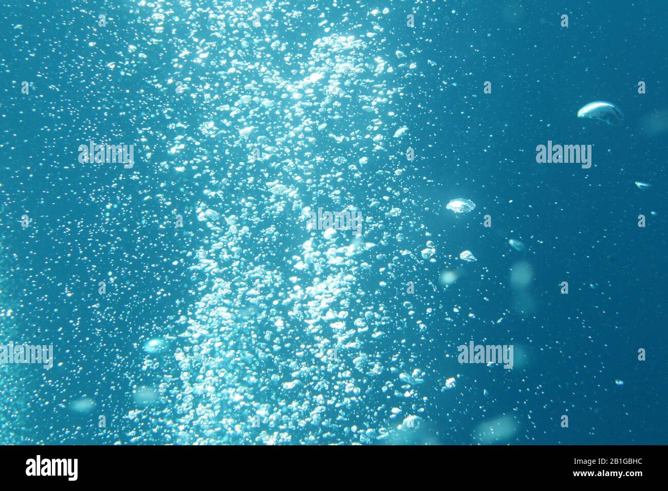 Blu oceano onde da sott'acqua con bolle. Raggi di luce che splendono attraverso. Ottimo per sfondi. Foto Stock