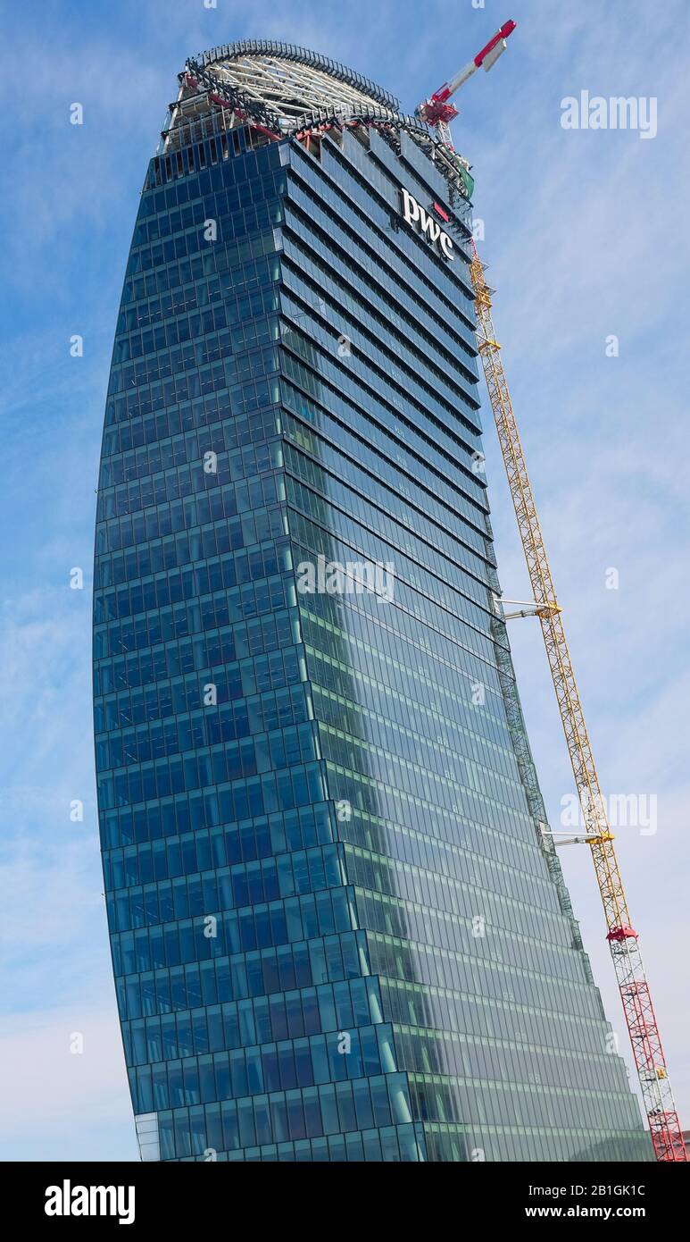 Grattacielo 'The Curved', chiamato anche Libeskind Tower, in costruzione a Citylife nel 2020, Milano, Italia. Con gru alta ancorata all'edificio Foto Stock