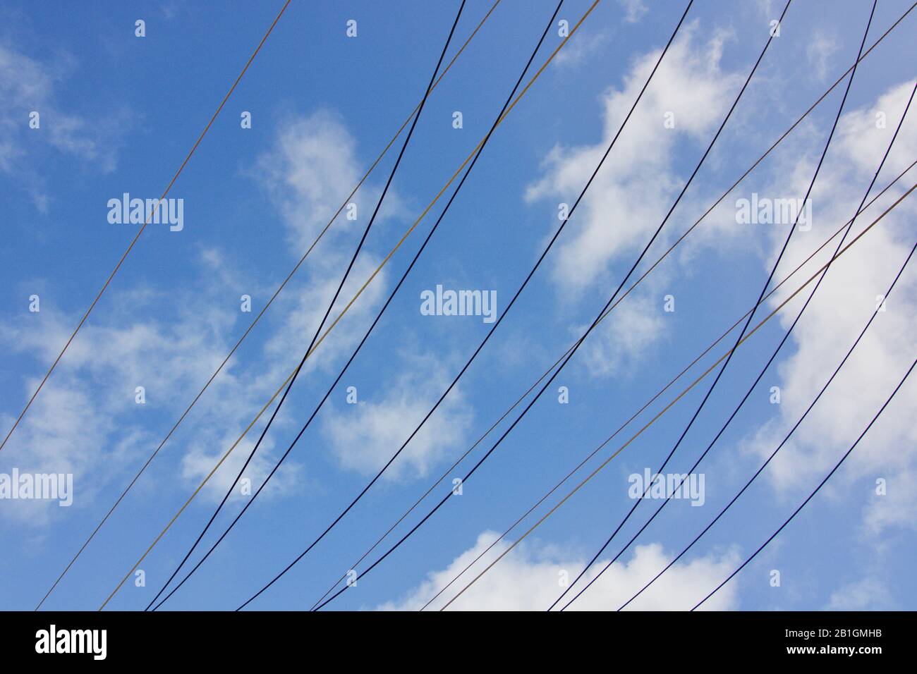 Cavi di alimentazione elettrici contro il cielo nuvoloso blu con spazio di copia Foto Stock