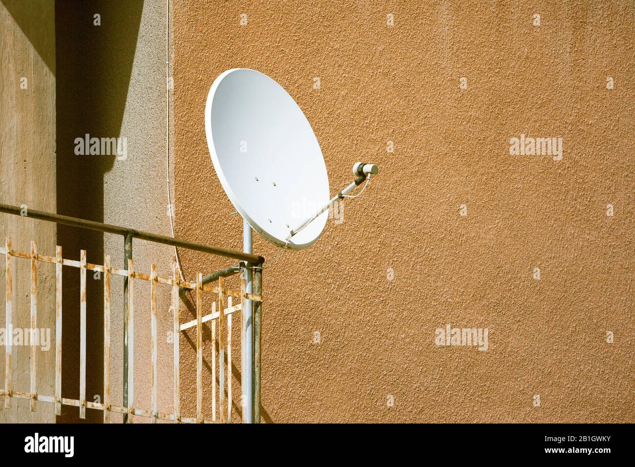 Piatto satellitare bianco installato su una ringhiera balcone Foto Stock