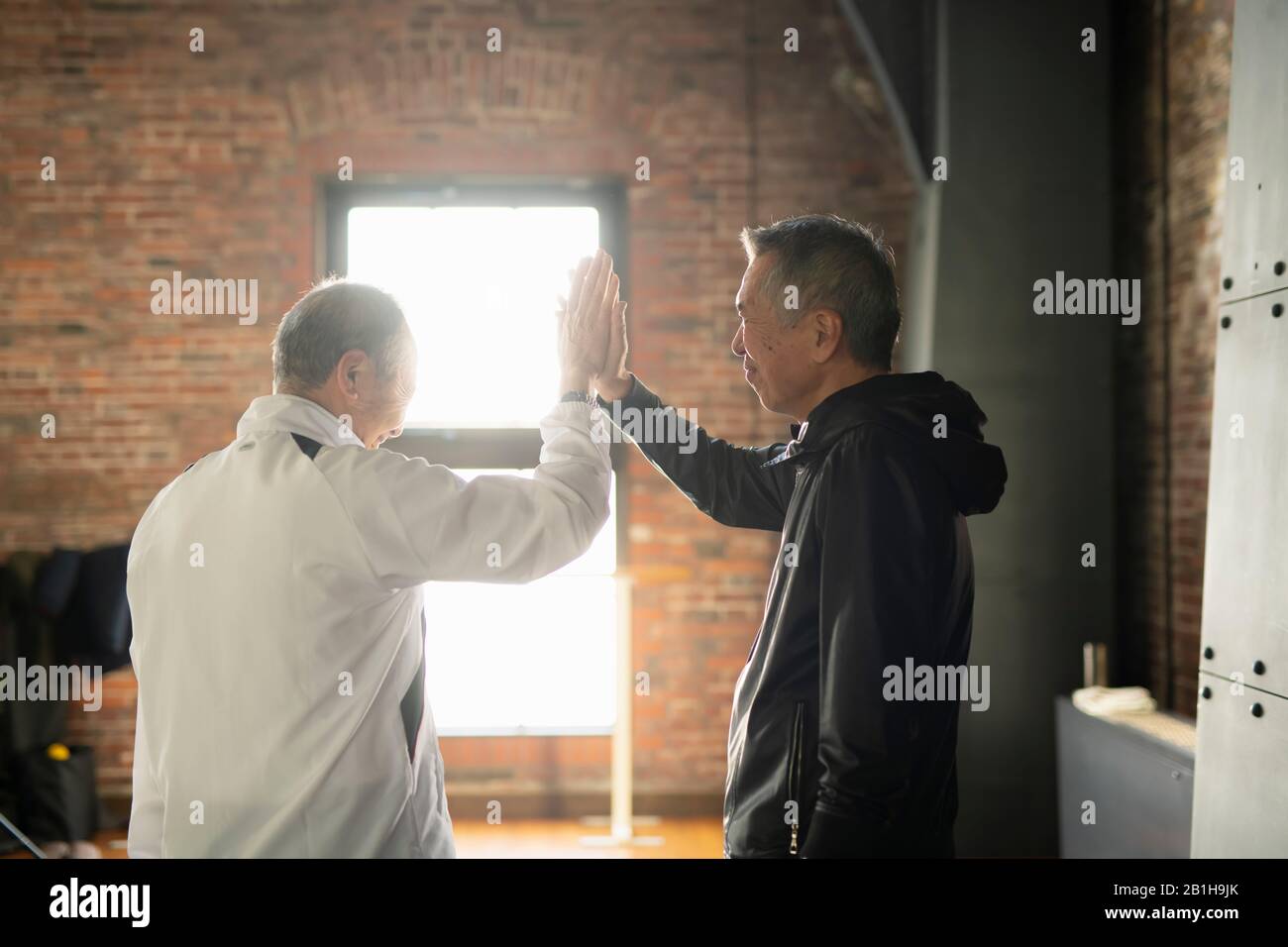 Due uomini anziani che fanno Hi-Five Foto Stock