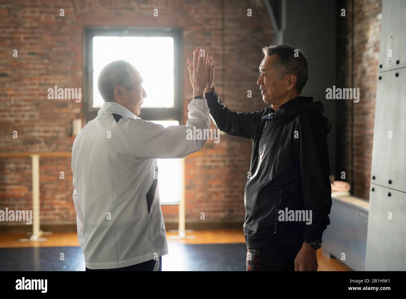 Due uomini anziani che fanno Hi-Five Foto Stock