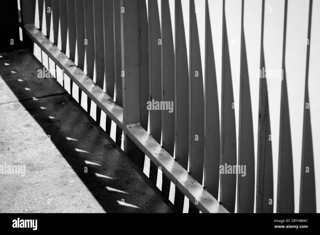 ringhiera bianca lungo la passerella della piattaforma ferroviaria Foto Stock
