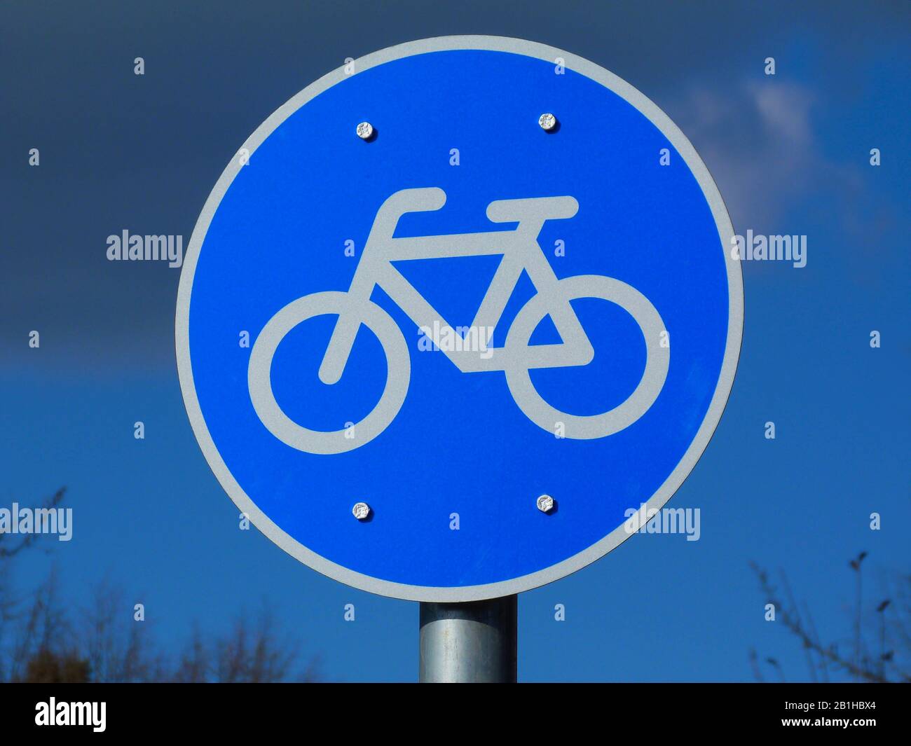 Strada circolare blu e segnaletica stradale. Bordo bianco e simbolo della  bicicletta che raffigura la pista ciclabile. Cielo blu dinamico e nuvole  bianche sopra. Concetto sportivo Foto stock - Alamy