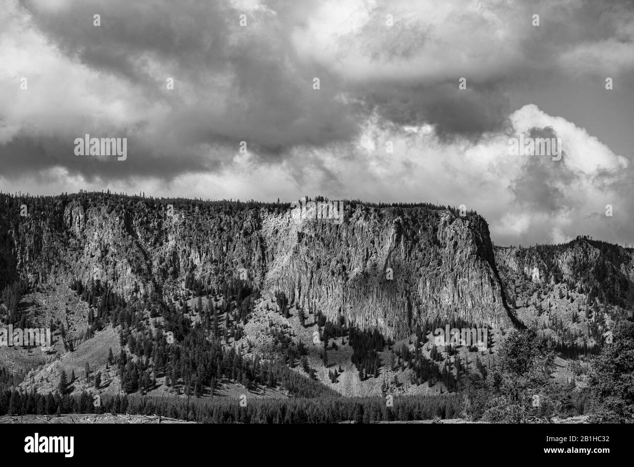 Guardando in alto sul versante montano sotto il cielo nuvoloso, bianco e nero. Foto Stock