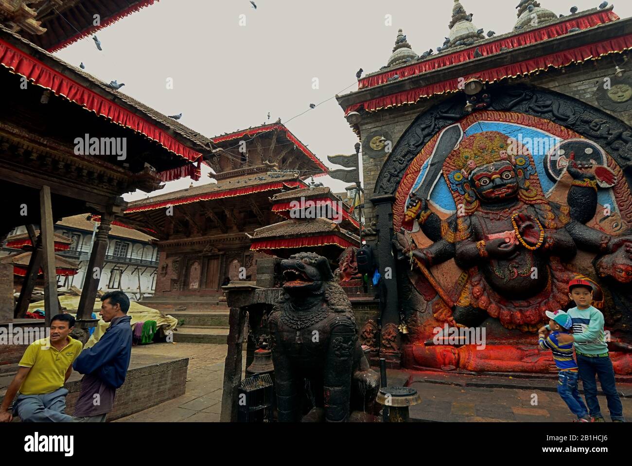 Persone che hanno tempo libero vicino all'immagine di Kala Bhairav (Lord Shiva) a Kathmandu Durbar Square, Kathmandu, Nepal. Foto Stock