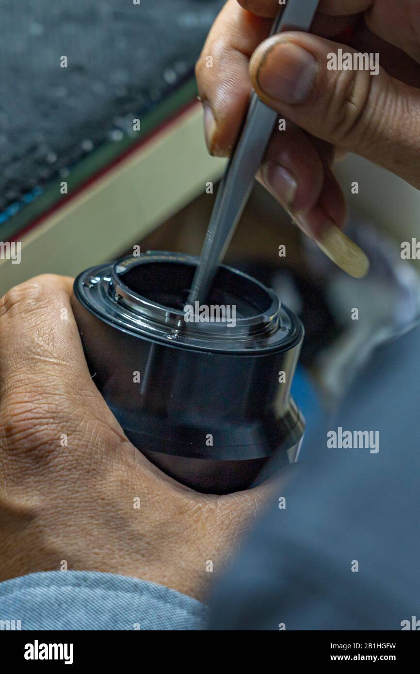 Il tecnico deve tenere le mani sugli attrezzi e pulire il sensore della telecamera Foto Stock