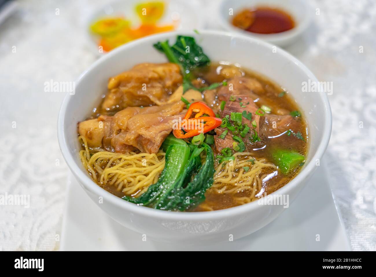 Deliziosa zuppa di noodle di manzo brasato in stile cinese su sfondo bianco Foto Stock