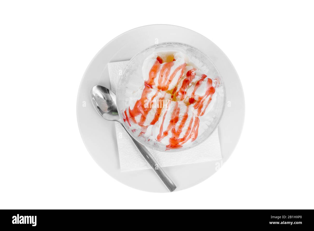 Quattro palle gelato dessert, aroma vaniglia con fragola, condimenti di bacche, isolato su uno sfondo bianco in crema su un piatto con un cucchiaio e una n Foto Stock