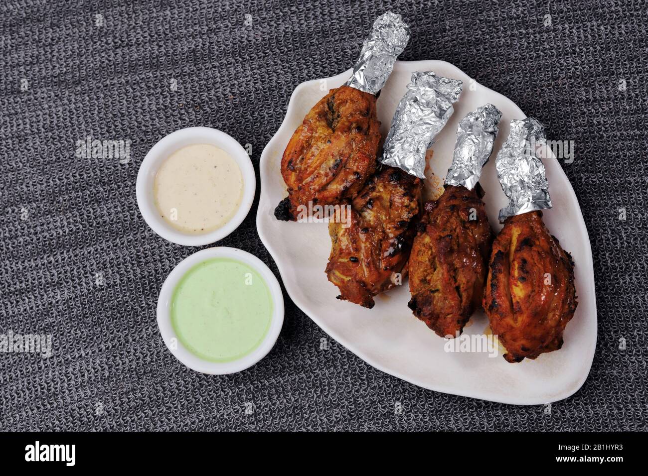 Cosce di tandoori di pollo fatte con pungente marinata di spezie e yogurt e cotte in tandoor o forno Foto Stock