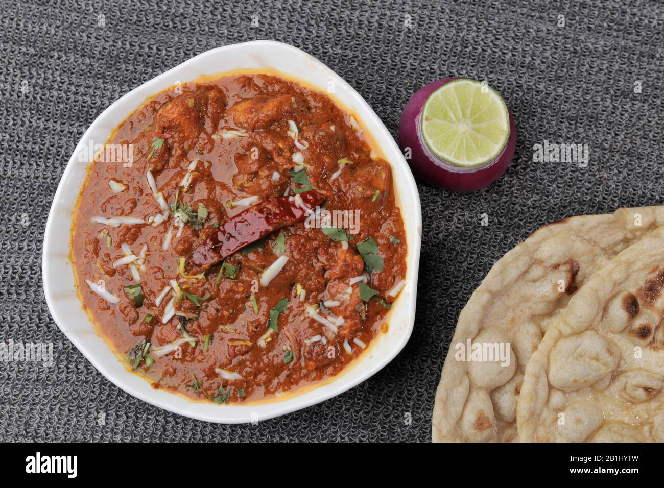 Curry di pollo servito con roti o pane indiano Foto Stock