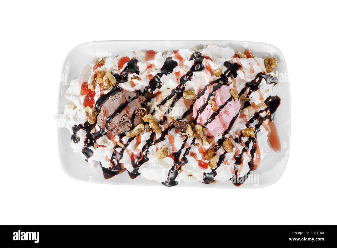 Dessert di gelato alla vaniglia, panna montata, noce, cioccolato e condimenti di frutti di bosco, split, sfondo bianco isolato su piatto quadrato. Piatto per il menu Foto Stock