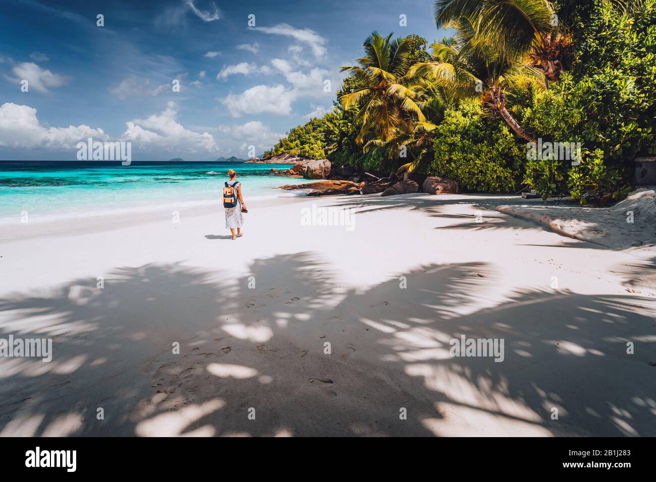 Turista femminile godersi la vacanza estiva sull'isola tropicale. Spiaggia di sabbia, con ombre di palme e blu laguna dell'oceano. Paradiso esotico ricreazione Foto Stock