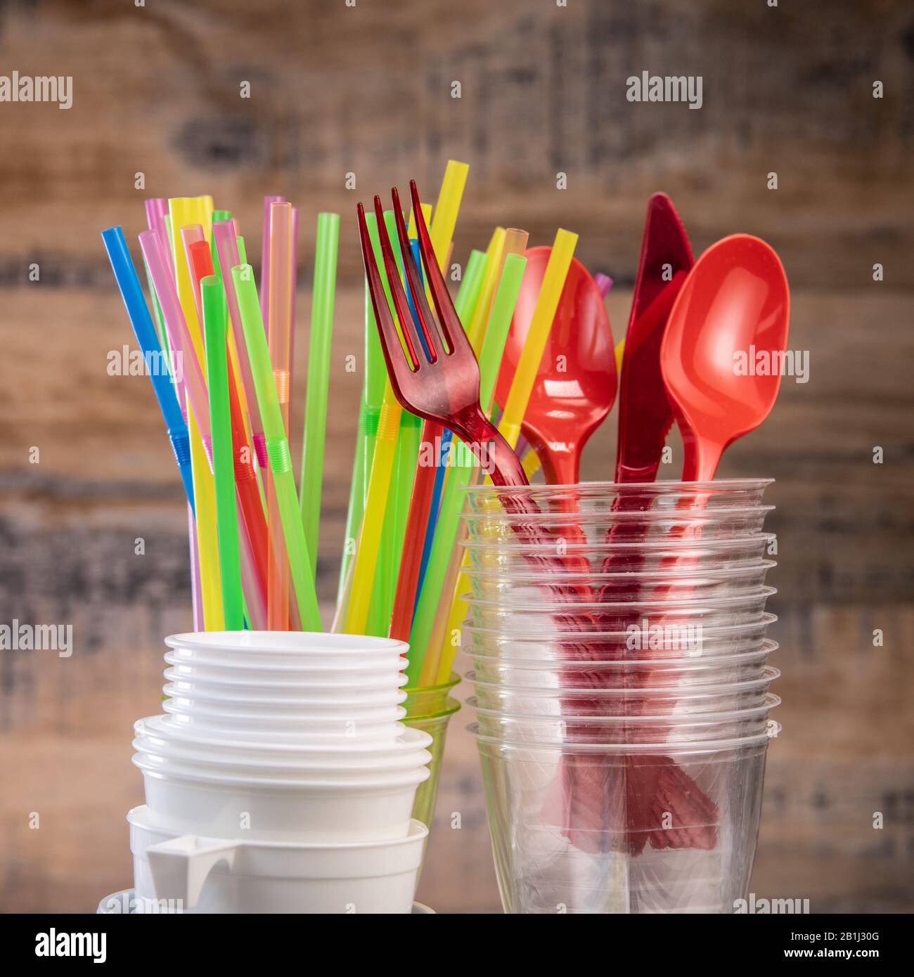 Rifiuti giornalieri di plastica, vari utensili di plastica, protezione ambientale su sfondo di legno Foto Stock