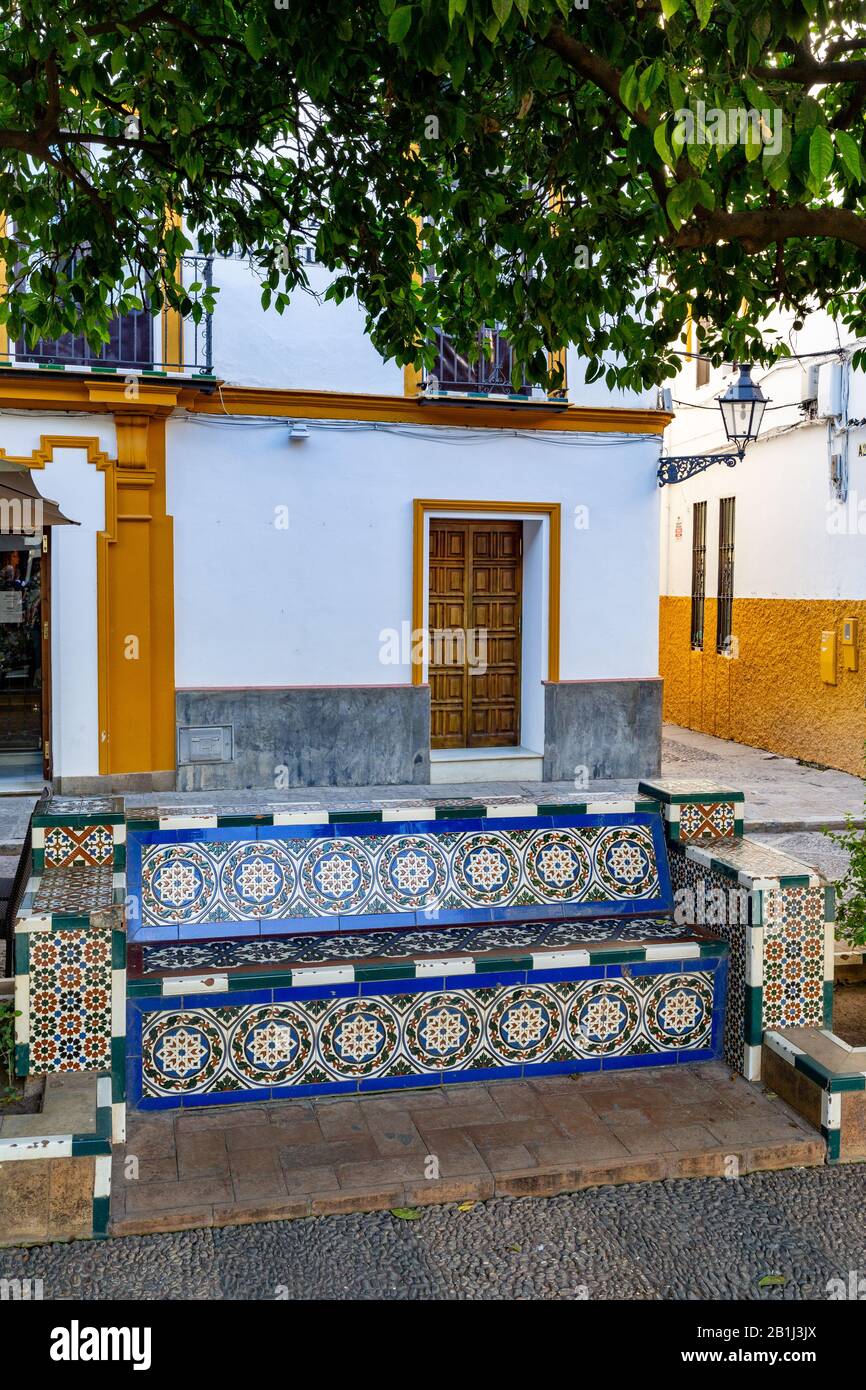 Panchina decorata con piastrelle dipinte in un parco nella città vecchia di Siviglia, Andalusia, Spagna. Foto Stock
