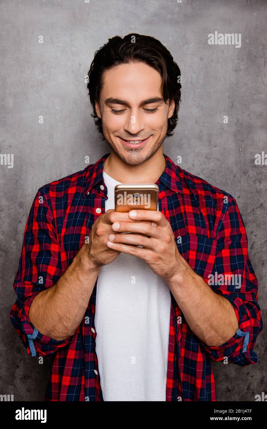 Ritratto di messaggio di tono felice sullo smartphone su sfondo grigio Foto Stock