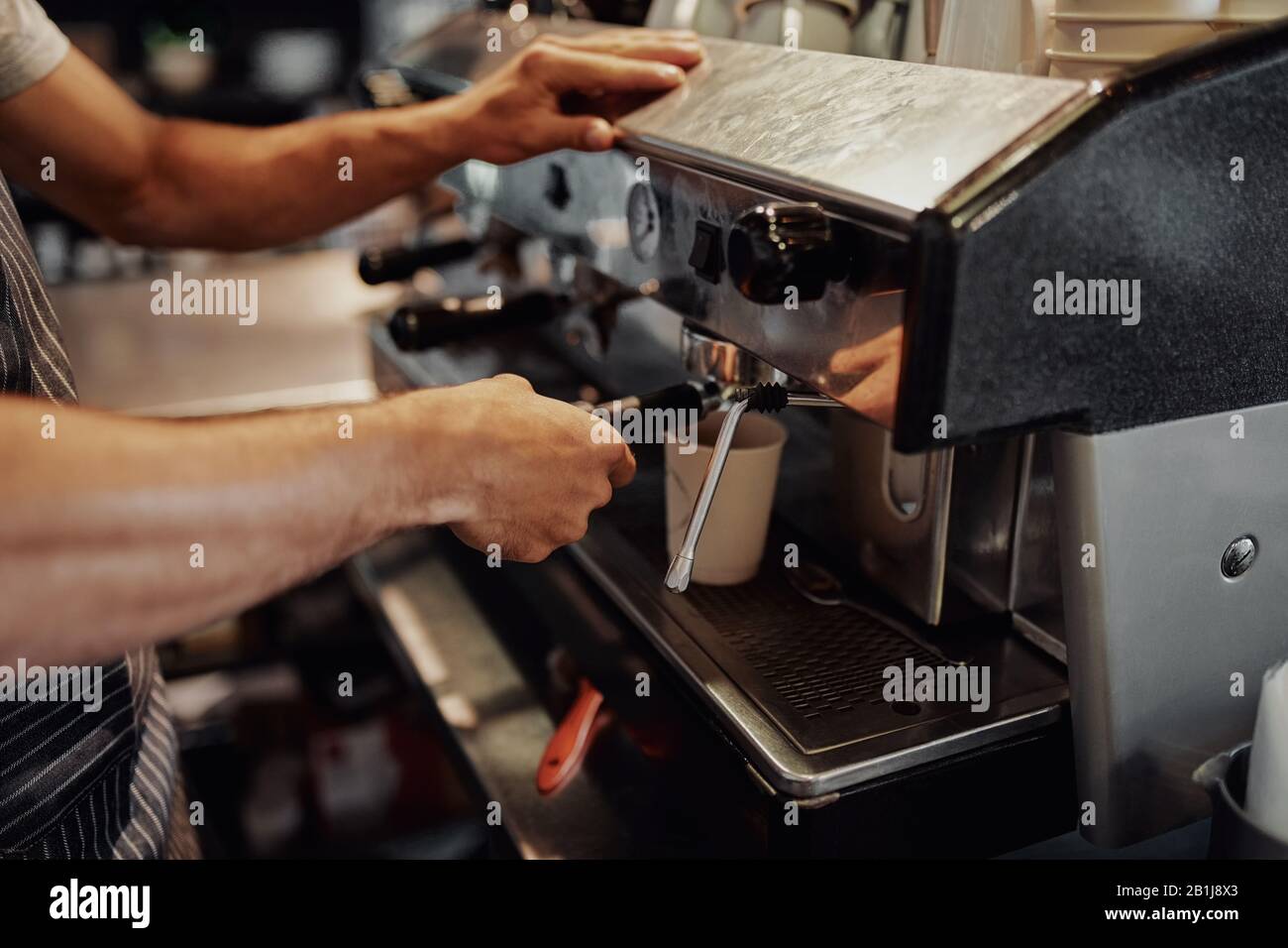 C'era una manina di cameriere che faceva il caffè dalla macchina nel caffè Foto Stock