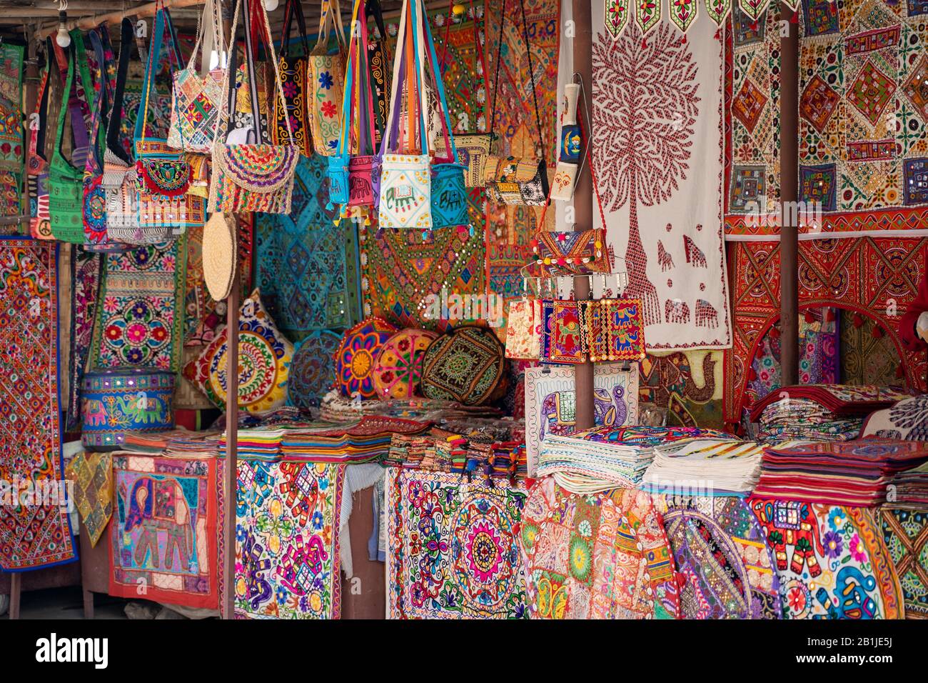 Vivace, colorato mercato stallo che vendono artigianato ricamato come borse a cuscino, borse tote e e coperte Foto Stock