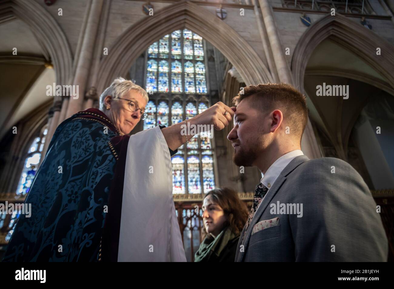 Lo staff del Minster di York Lisa Power e Danny Knight ricevono il segno della croce segnata in cenere sulle loro teste di fronte, dal Revd Maggie McLean, Missionario canonico a York Minster, durante L'Imposizione di Ashes il Mercoledì delle Ceneri. Foto Stock