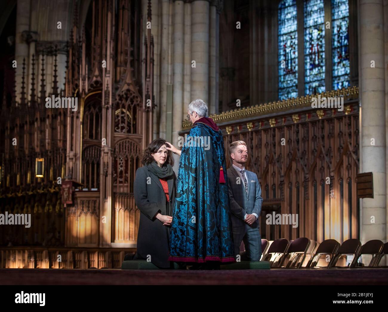 Lo staff del Minster di York Lisa Power e Danny Knight ricevono il segno della croce segnata in cenere sulle loro teste di fronte, dal Revd Maggie McLean, Missionario canonico a York Minster, durante L'Imposizione di Ashes il Mercoledì delle Ceneri. Foto Stock