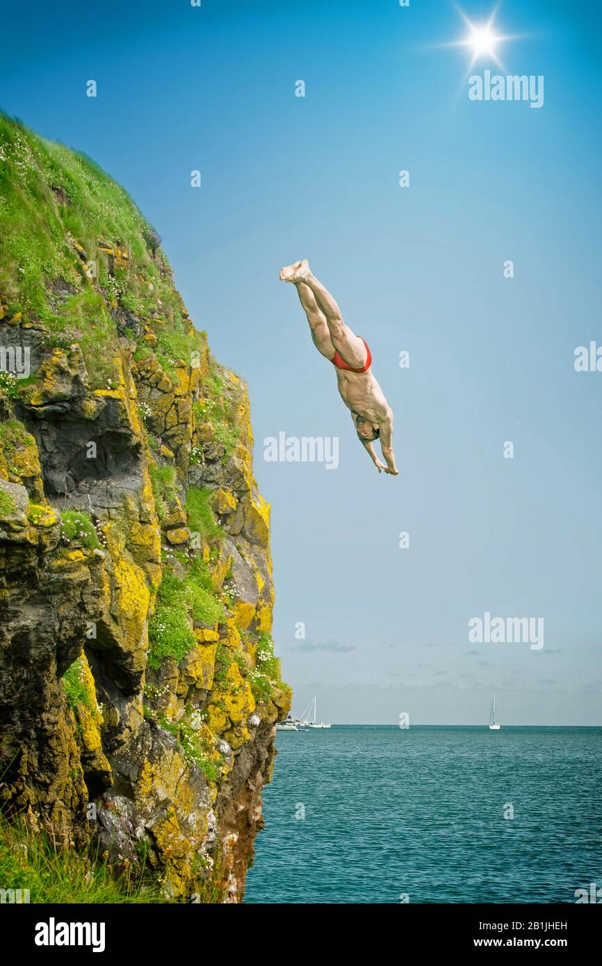 Uomo che salta da una scogliera nel mare, Germania, Baviera Foto Stock