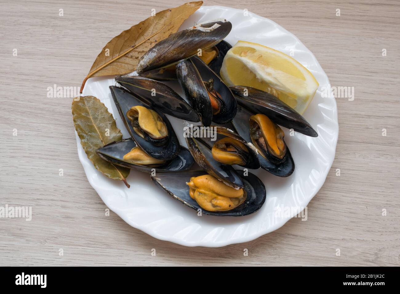 piatto di cozze cotte con limone e foglia di alloro Foto Stock