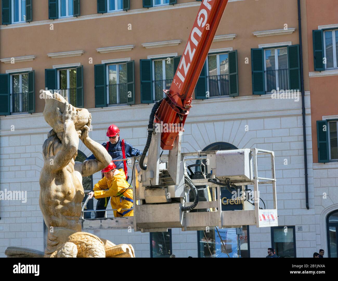 Operai che puliscono la statua della Fontana del Tritone a Roma, Italia Foto Stock