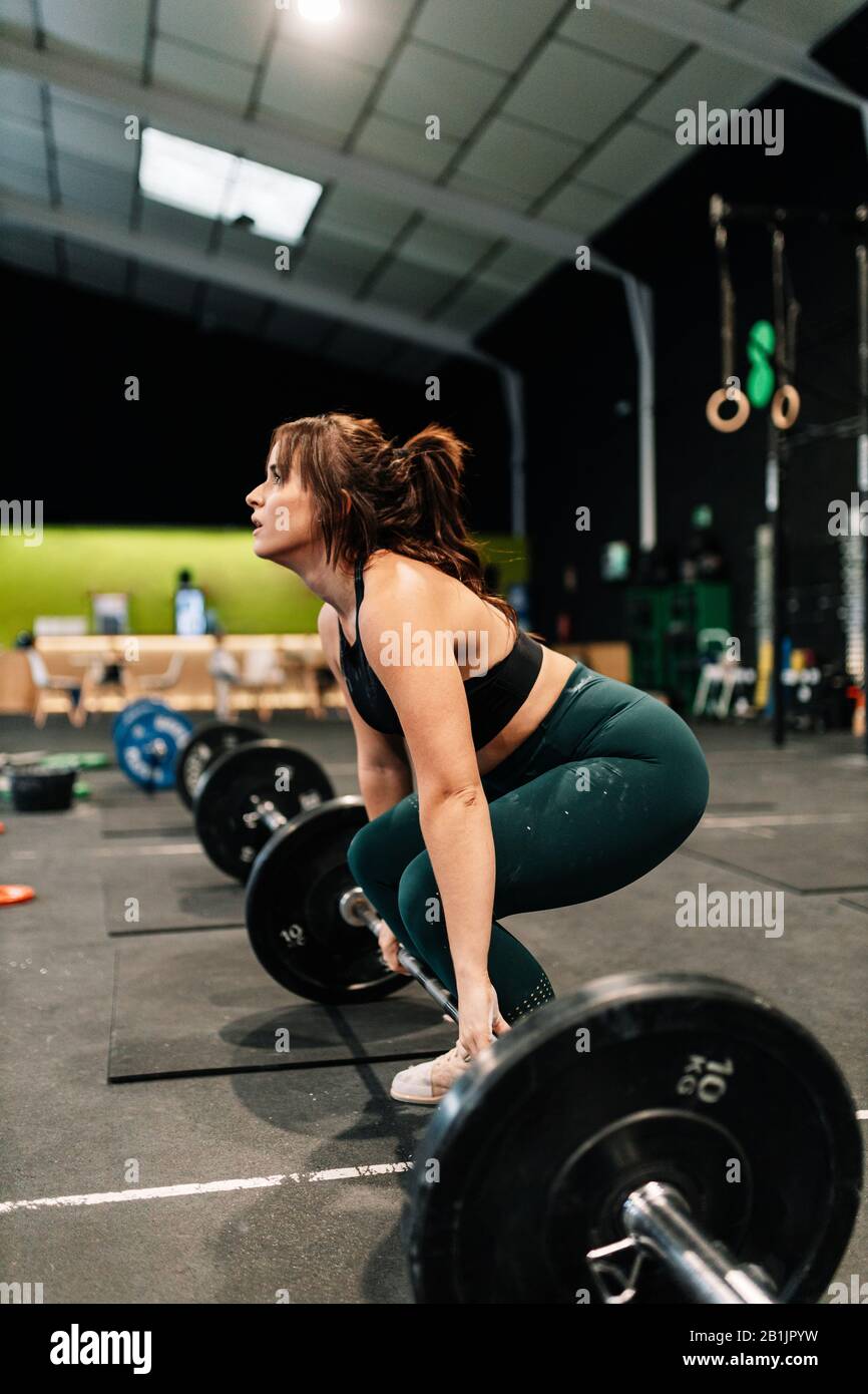 Potente sollevatore per sollevamento pesi femmina che si prepara per il sollevamento in palestra. Foto Stock