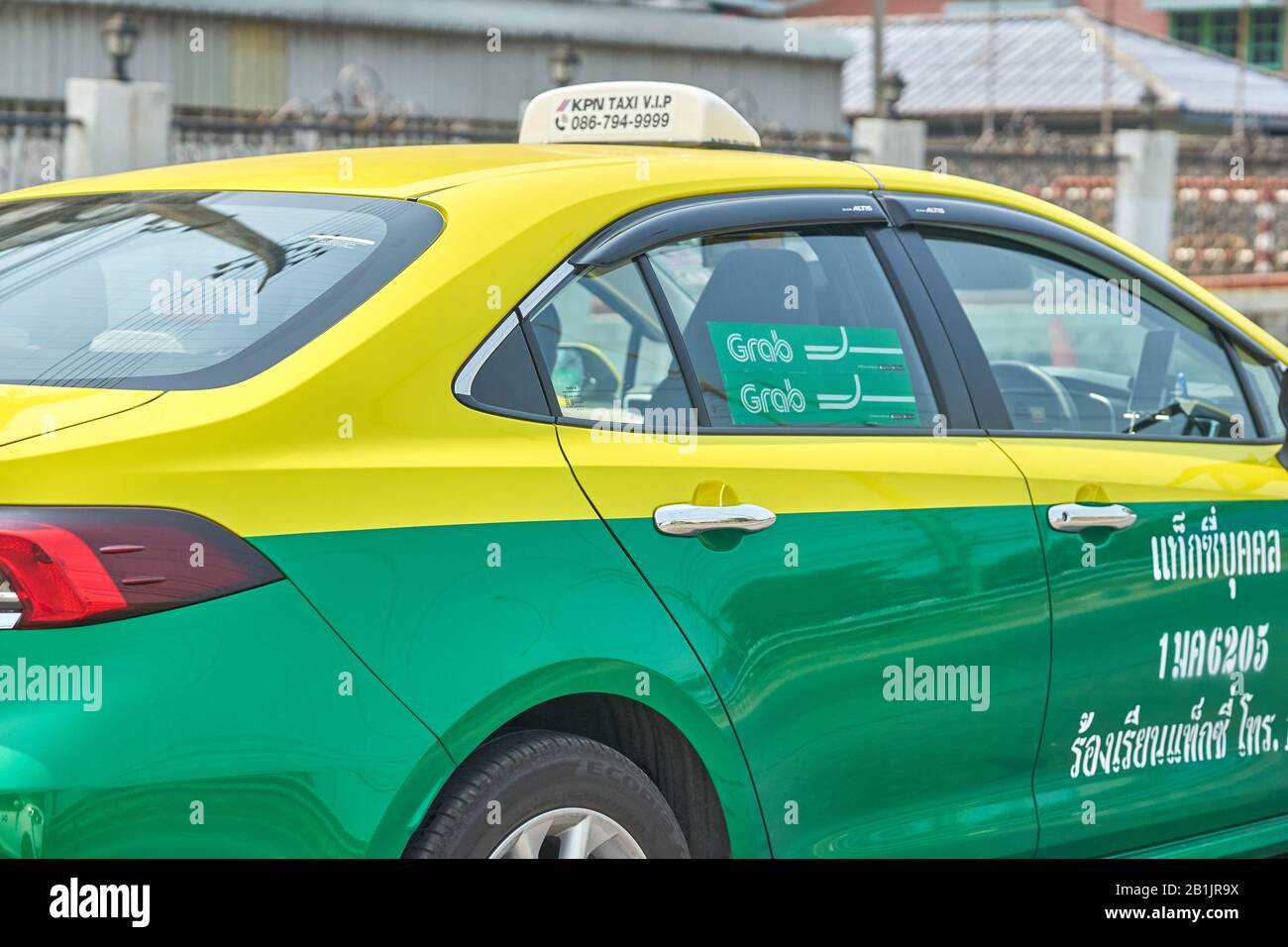 Una Bangkok Grab taxi servizio auto, in colore verde e giallo tradizionale. Foto Stock