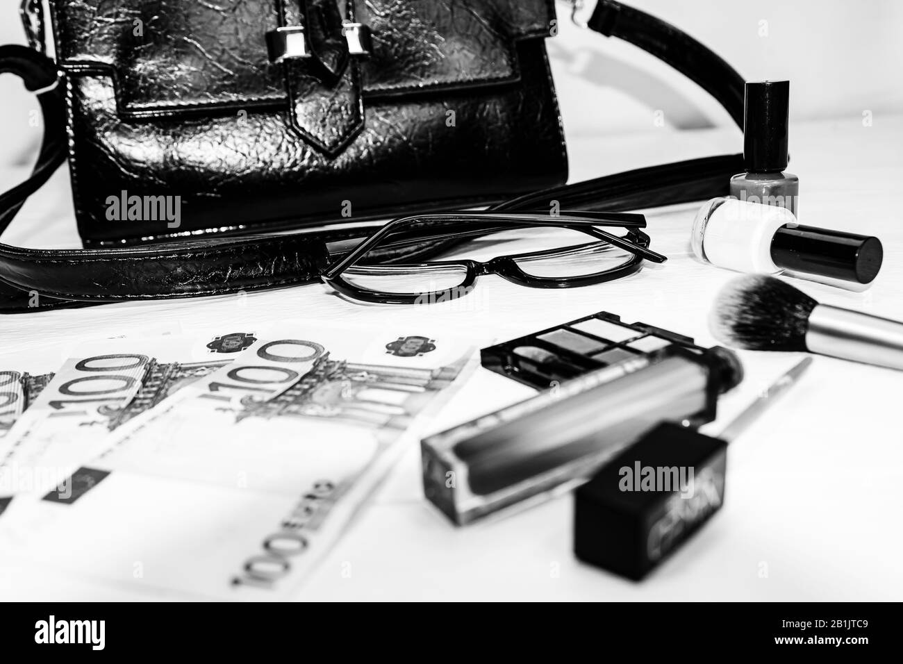 Elegante borsa con soldi e cosmetici prodotti di bellezza isolato su sfondo bianco con spazio copia. Foto Stock