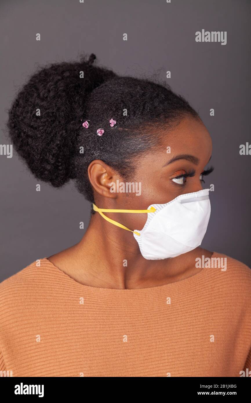 Giovane donna che indossa una maschera protettiva per il viso Foto Stock