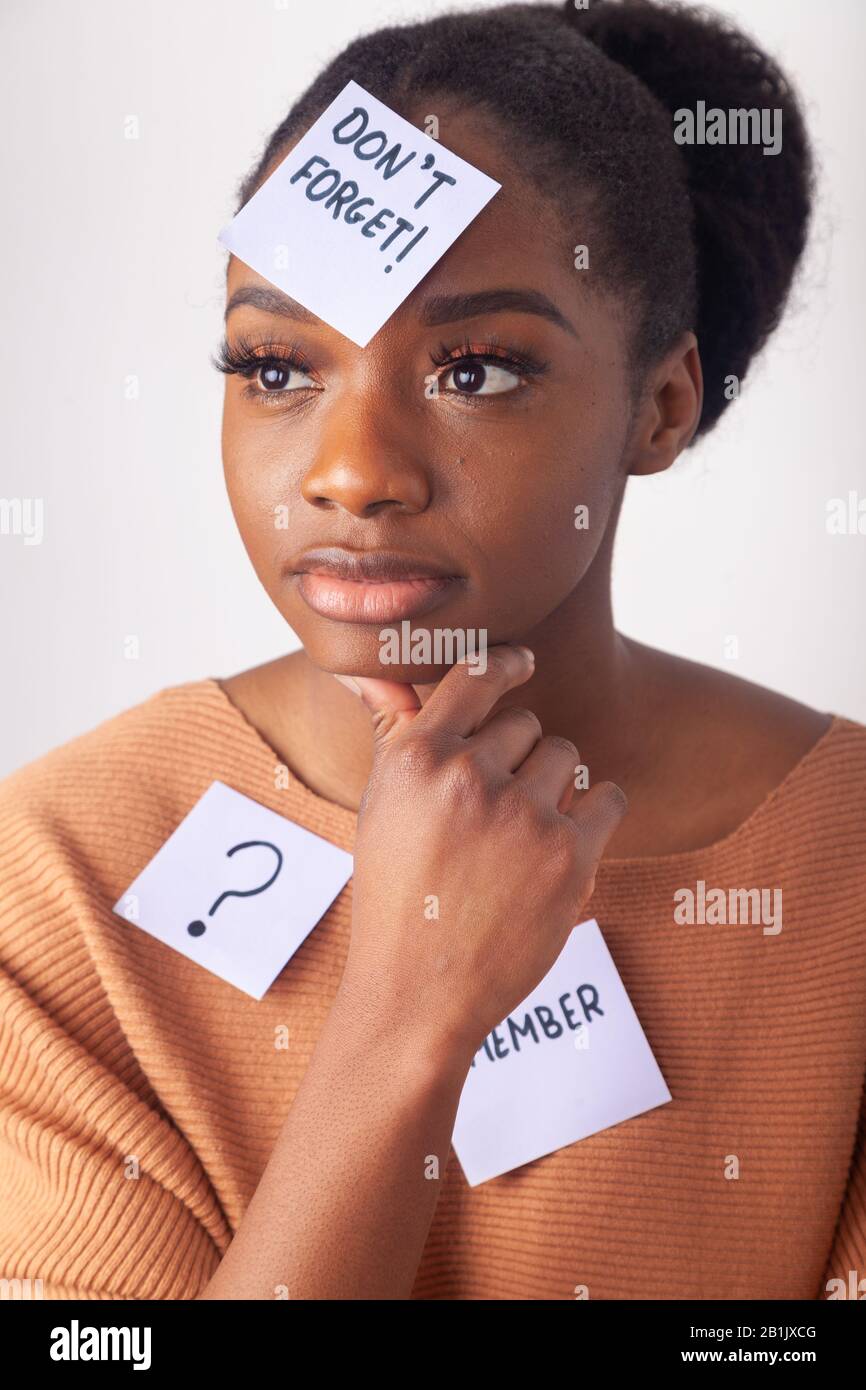 Giovane donna nera con una nota adesiva sulla fronte dicendo non dimenticare. Foto Stock