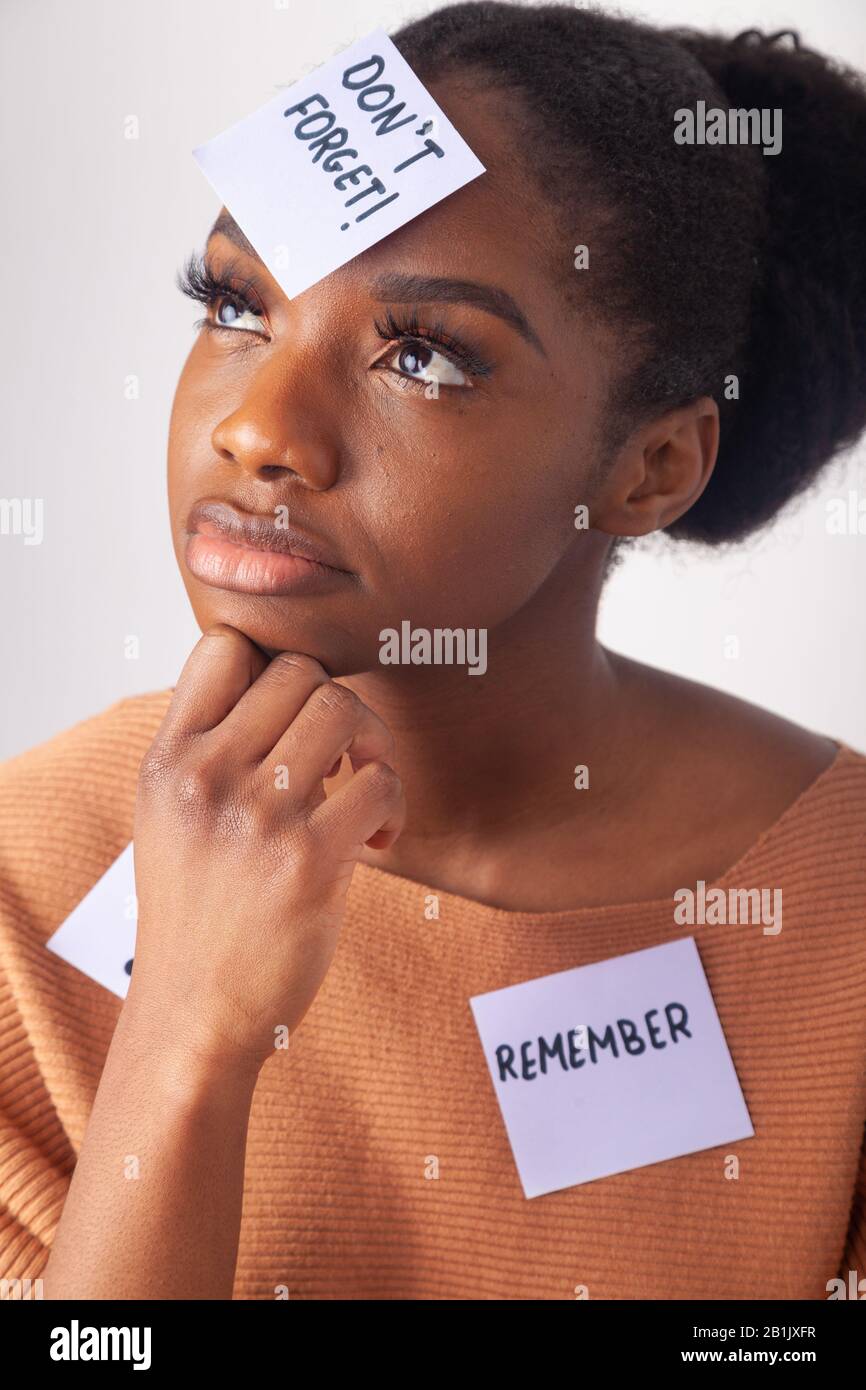 Giovane donna nera con una nota adesiva sulla fronte dicendo non dimenticare. Foto Stock