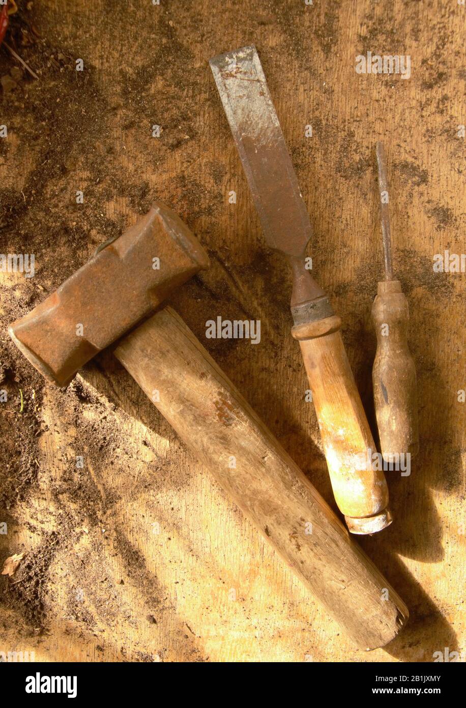 Vecchi utensili in legno arrugginiti su un tavolo in legno. Scalpello a martello e cacciavite Foto Stock