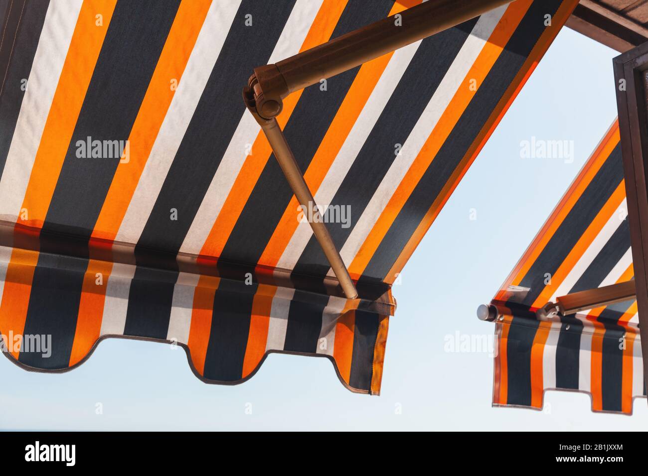 Patio pieghevole tenda balcone, parasole laterale sotto un luminoso cielo estivo Foto Stock
