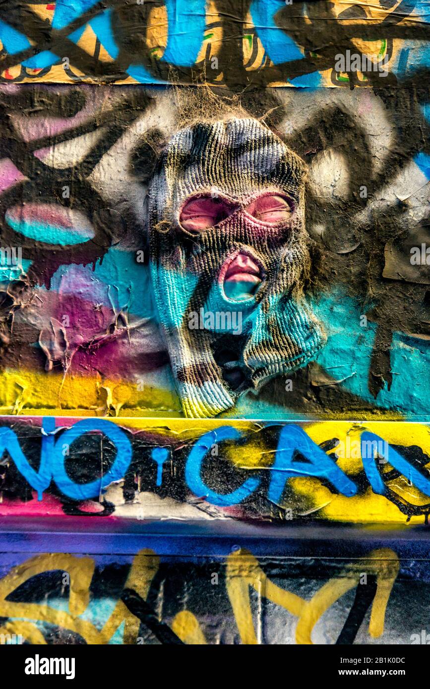 Uomo spaventoso maked che emerge da graffiti coperto muro di mattoni, Hosier Street, Melbourne Lanes, Melbourne, Victoria, Australia Foto Stock