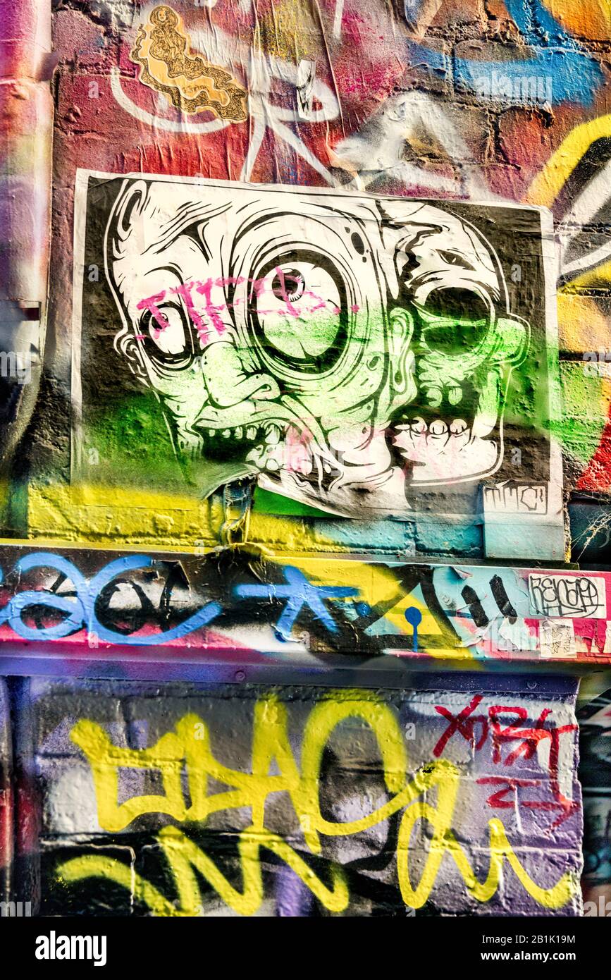 Un poster dall'aspetto pazzo sulle colorate pareti in mattoni pieni di graffiti, Hosier Street, Melbourne Lanes, Melbourne, Victoria, Australia Foto Stock