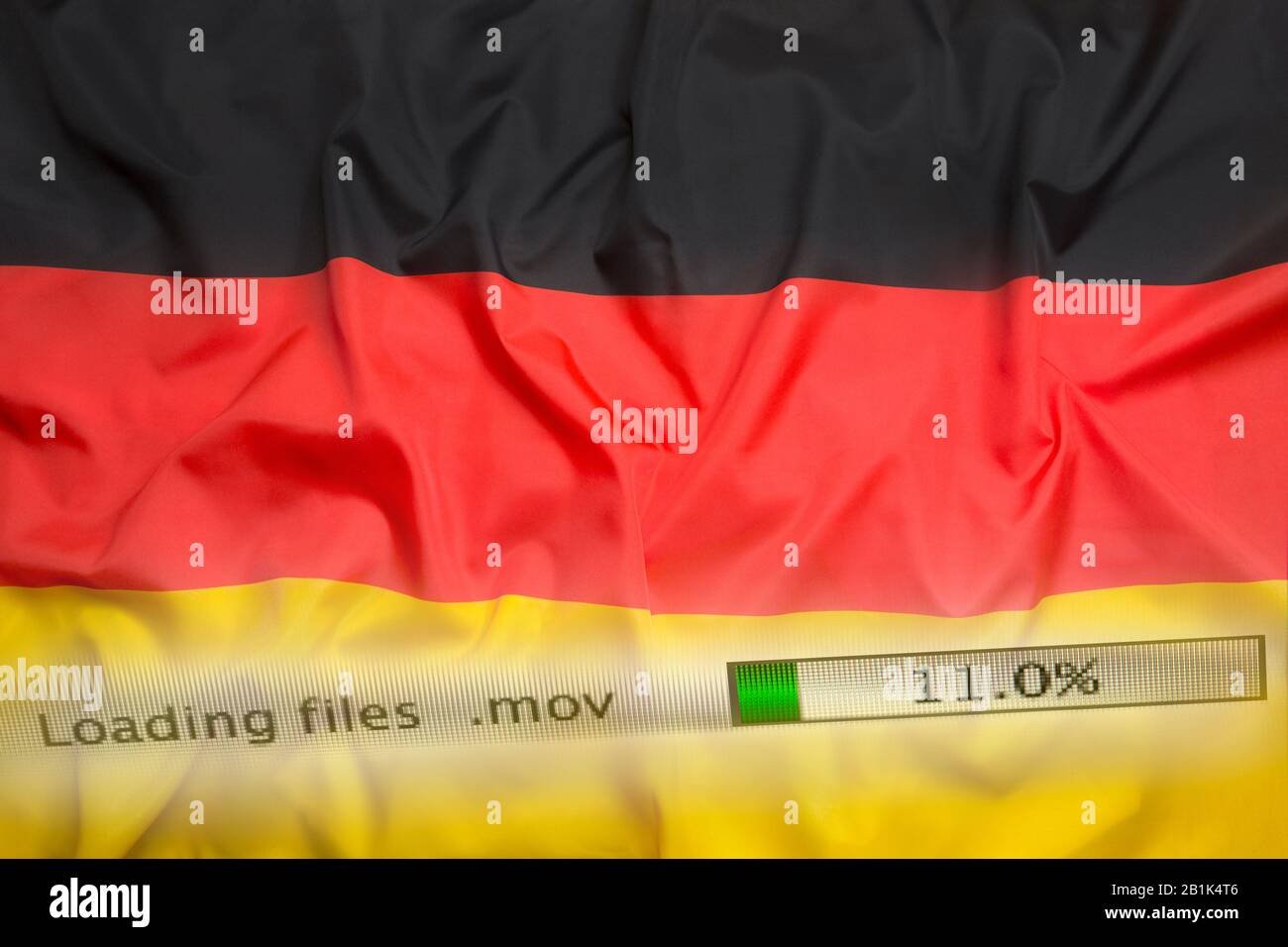 Il download di file su un computer con la bandiera della Germania Foto Stock